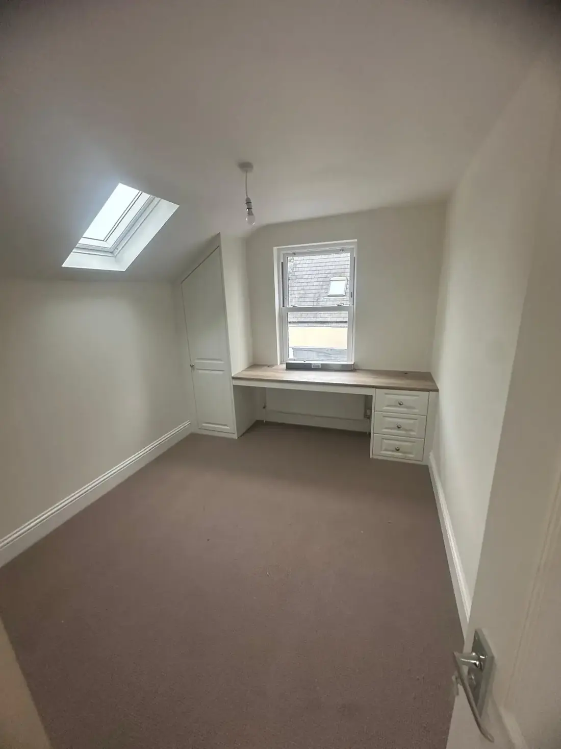 Completed loft conversion bedroom in Oxford with a rooflight and sloped ceiling