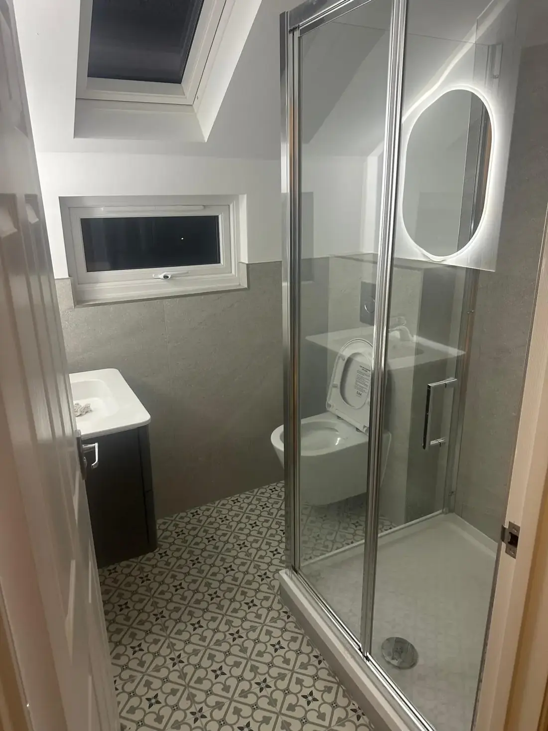 Loft shower room in Oxford finished with a corner enclosure and tiled floor